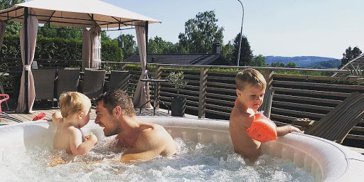 Očka in njegova otroka se sproščajo v masažnem bazenu.